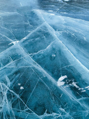 Abstract natural ice texture. Freezy ice surface. Blue backdrop with cracks and scratches on frozen water.