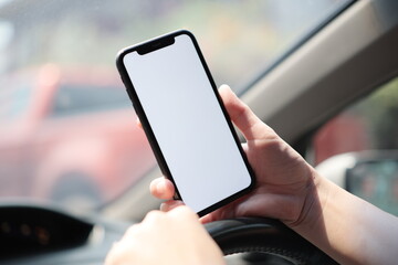 hand holding mobile phone in car