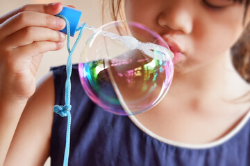 girl blowing bubbles with glass of water in summer fun
