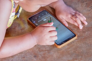 baby holding a phone while, with a processor nearby