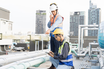 Group of male plumber working and inspecting quality of water pipes system at rooftop of building. Team of Asian male plumber maintenance water pipes network system on building rooftop