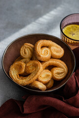 Naklejka premium Palmiers or elephant ears, puff pastry cookies in the bowl