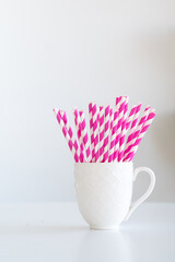 Pink paper straws on white background