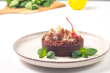 Delicious chocolate tart garnish with cherry and mint. Classic dessert. - 760444542