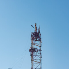 tower for mobile communication antennas against a blue sky with white clouds. Mobile operator...