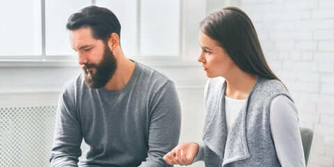 Disappointed wife blaming her depressed husband at marriage counselling session