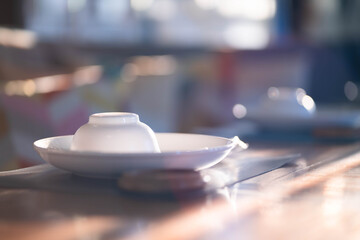 Cups and plates on the dining table bokeh light background