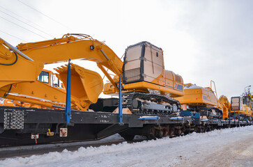 Excavators crawler transported by rail. Crawler dozers secured for rail transport. A train with wagons on a railway siding with excavators crawler. © Leszek Szelest