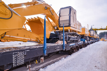 Excavators crawler transported by rail. Crawler dozers secured for rail transport. A train with...