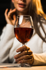Young woman holding a glass of wine.Woman drinking wine in a restaurant.Red wine concept