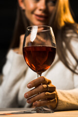 Young woman holding a glass of wine.Woman drinking wine in a restaurant.Red wine concept