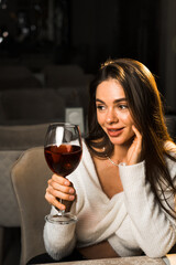 Young woman holding a glass of wine.Woman drinking wine in a restaurant.Red wine concept
