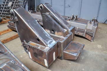Preparation of welded parts for assembly of crawler dozers and wheel loaders. Storage station spare parts before painting components. Crawler bulldozer assembly line. Heavy industry.