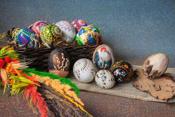 Decorative basket with colorful painted Easter eggs on a palm tree. Easter tradition