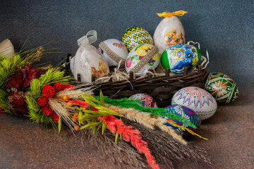 Decorative basket with colorful  Easter eggs on a palm tree. Easter tradition