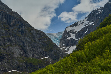 Fototapeta na wymiar Blue Bondhusbreen Glacier hanging in the mountains over the Bondhusvatnet Lake and in Sundal, Vestland, Norway