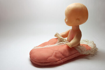 cute baby doll, sitting in handmade silk sleeping bag with white sewing lace trim