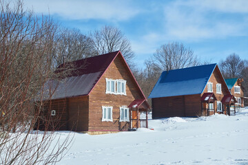 Wooden houses made of logs, covered with snow. A home for the northern regions of the planet. Ecological lifestyle