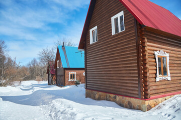 Wooden houses made of logs, covered with snow. A home for the northern regions of the planet. Ecological lifestyle