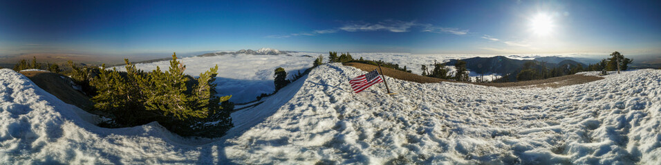 A panoramic view of a snowy mountain with american flag