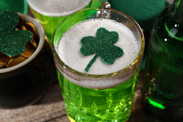 St. Patrick's day party. Green beer, leprechaun pot of gold and decorative clover leaves on wooden...
