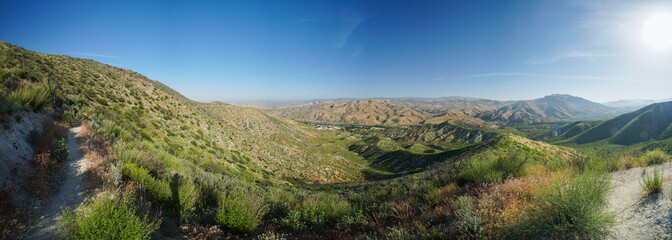 A panoramic view of a desert landscape with a clear blue sky