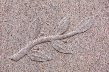 A design of tree branch engraved on gravestone in cemetery.