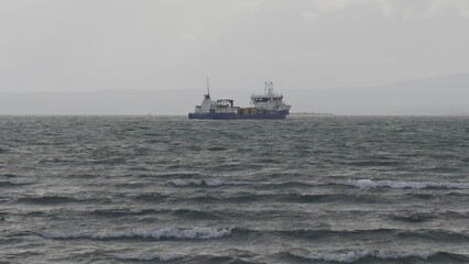 Gloomy Day at Sea: Fishing Vessel Facing Rough Waves