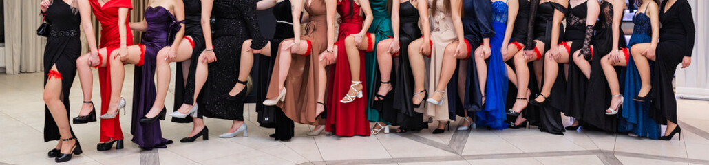 Fototapeta na wymiar Young girls showing off their legs with red garters during the high school prom, also called 