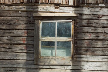 Closeup of old weathered and worn wooden planks with framed window.