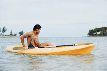 Happy Asian Man Kayaking on Tropical Beach, Enjoying Summer Vacation