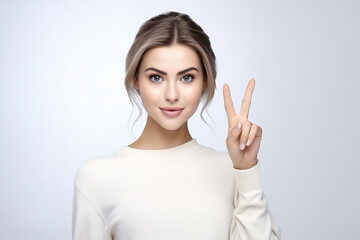 Beautiful woman gesture victory sign on plain background