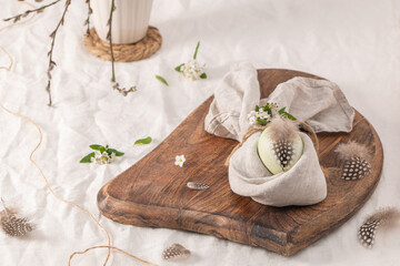 Stylish Easter brunch table setting with egg in easter bunny napkin.