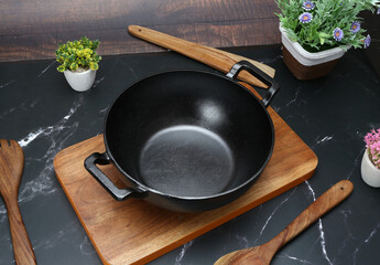 Black non stick deep Karahi on the wooden choping board