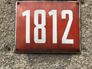 Red numberplate that says 1812