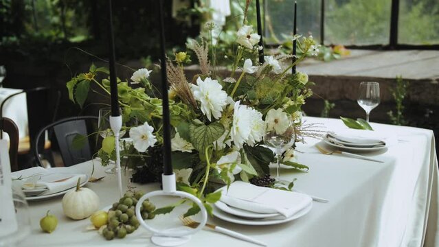 Elegant table with plates, candles, and flowers set up for an event. Wedding day
