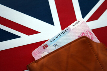 Residence Permit BRP card in purse on Union Jack flag close up
