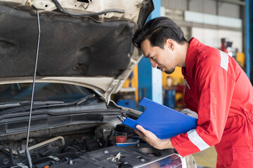 Male mechanic working at garage. Professional Asian male mechanics checks, repair and maintenance...