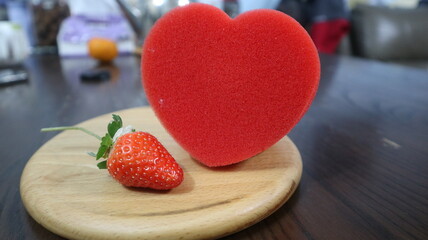 wooden board with red heart and strawberry design for love and romantic concept