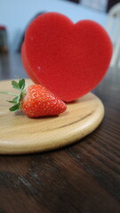 wooden board with red heart and strawberry design for love and romantic concept
