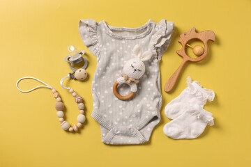 Different baby accessories on yellow background, flat lay - obrazy, fototapety, plakaty