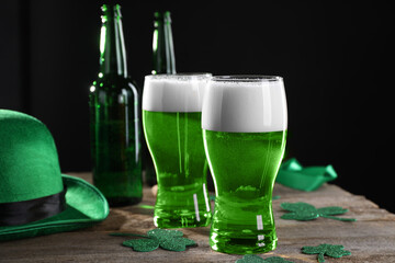 St. Patrick's day party. Green beer, decorative clover leaves and leprechaun hat on wooden table