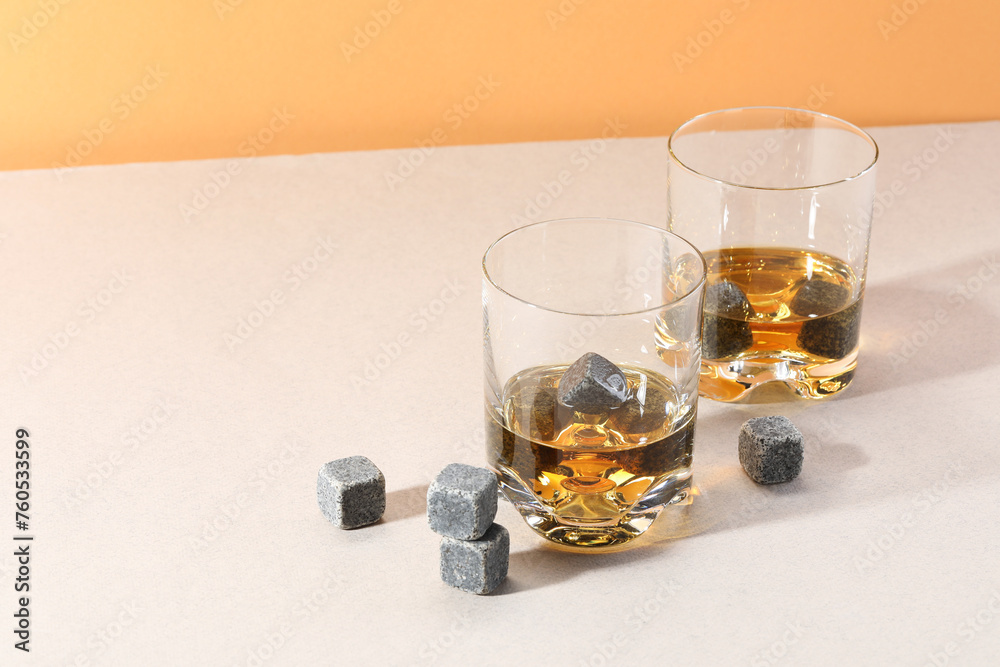 Canvas Prints Whiskey stones and drink in glasses on light table. Space for text