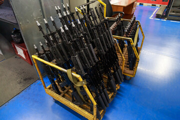 Naklejka premium Modern assault rifles at storehouse of big military plant.