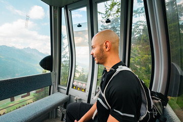 Men HIker Sitting in Cable Car Watching the Mountain Landscape