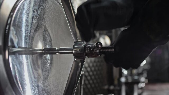 Turning the bulkhead valve of a chrome tank for egalizing and settling wine at the winery. Close-up 