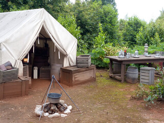 Campement avec tente, table et feu de bois type Robinson Crusoé ou Davy Croquett - obrazy, fototapety, plakaty