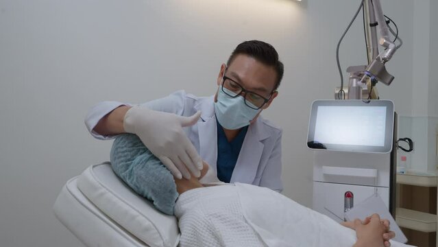 Side view of asian woman getting resurfacing laser fraxel dual and ultrasound face treatment in medical spa center. skin rejuvenation concept	