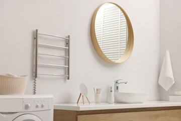 Stylish bathroom interior with heated towel rail and washing machine