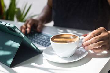 Female blogger works at a tablet computer and maintains her social networks. Concept of marketing, SMM and content creation in social networks. Morning Strong Coffee for Work